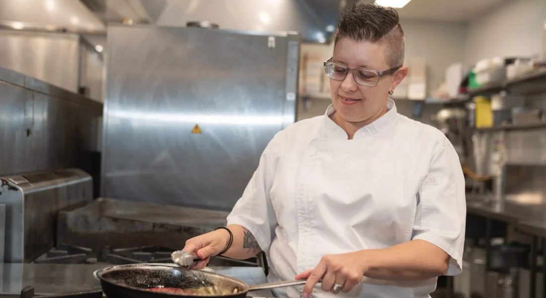 Chef cooks with a fry pan in a commercial kitchen