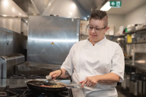 Chef cooks with a fry pan in a commercial kitchen