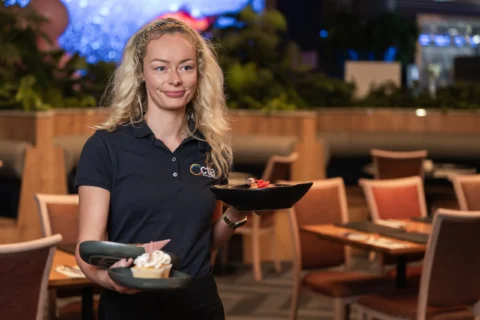 A waiter carries three dishes.