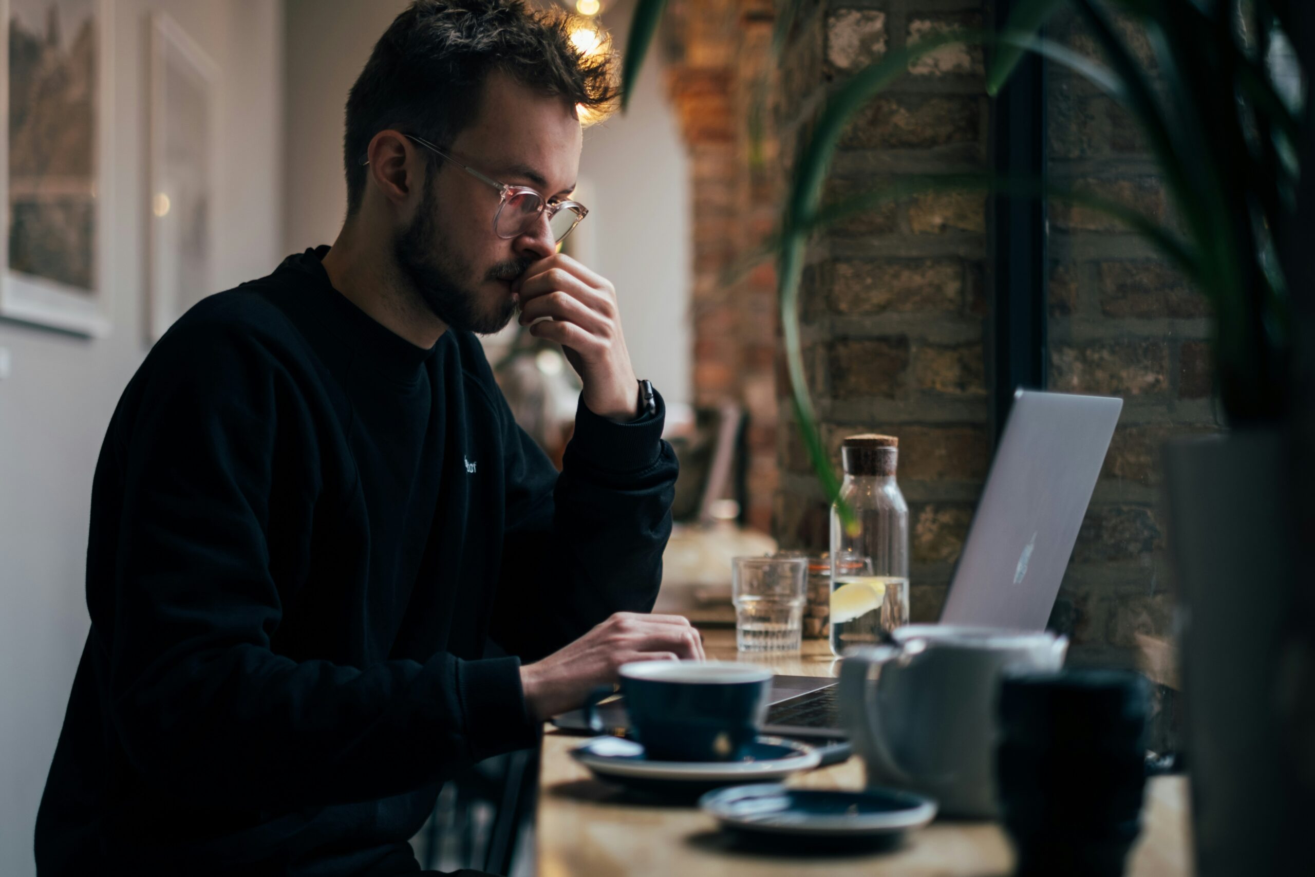 A man works on his laptop from a bar.